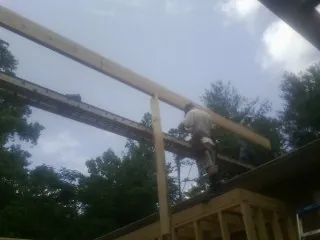 Carpenter setting a ridge beam over a new addition frame — Ice Dam Removal by Roofing Brothers in Pauline