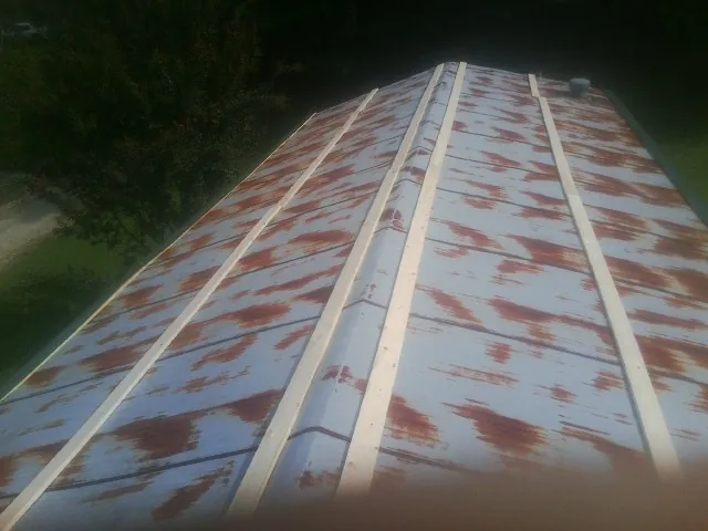 Rusted metal roof panels with new wood purlins before replacement — Storm Damage Roof Repair in Pauline by Roofing Brothers