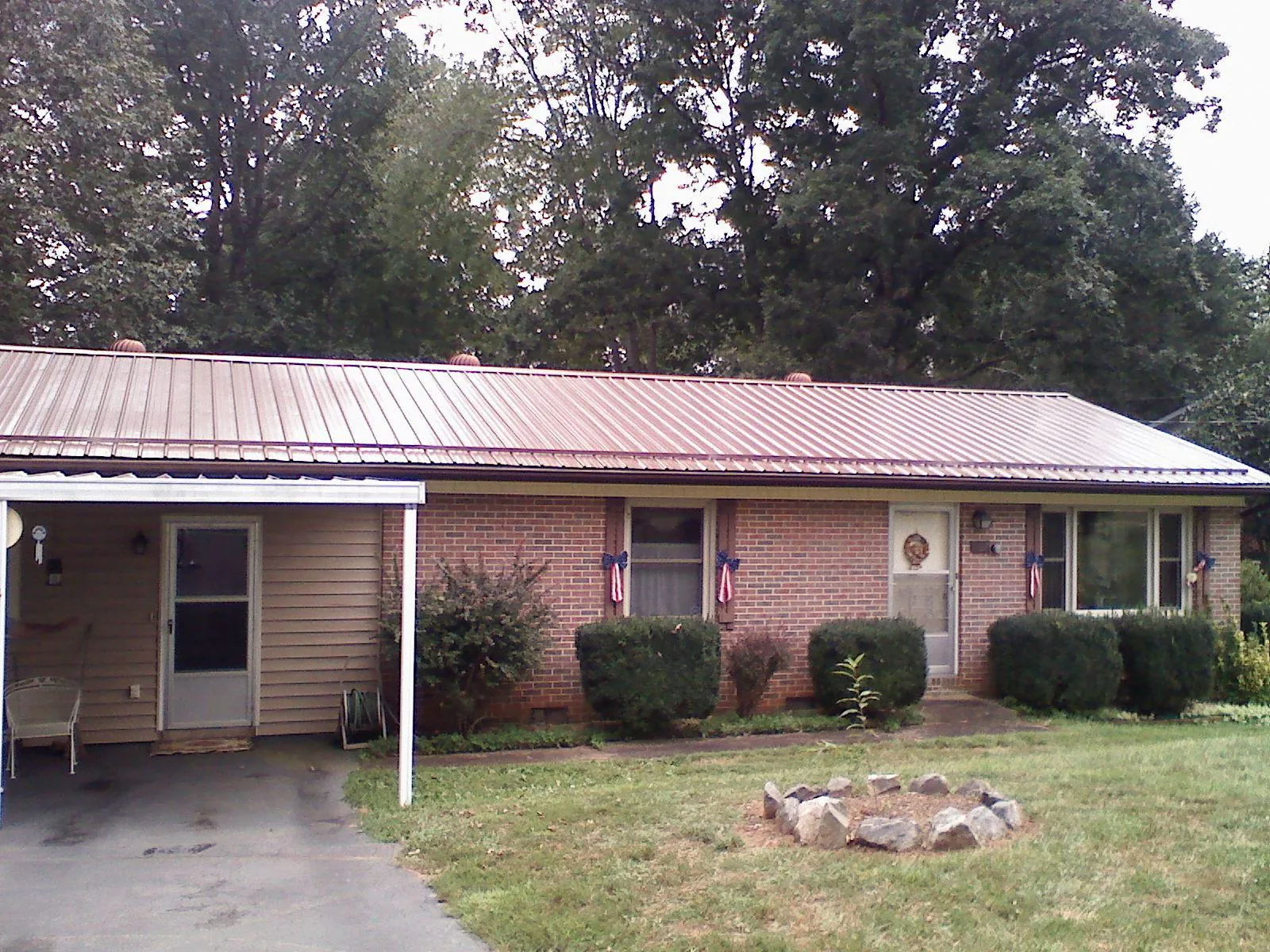 Bronze metal roof and carport on a brick ranch home — Roof Repair work by our crew in Pauline